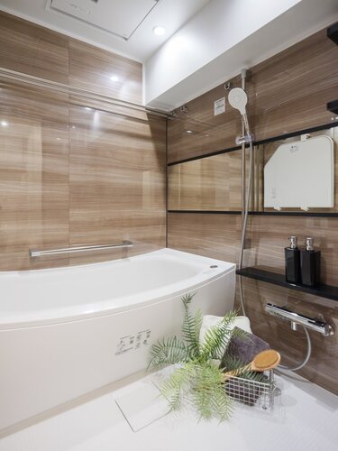 美しいカーブと全身を包み込むような入浴感が特長の浴槽が魅力のバスルームです。光沢感のある木目調タイルによって、より一層くつろぎの空間が演出されます。