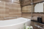 美しいカーブと全身を包み込むような入浴感が特長の浴槽が魅力のバスルームです。光沢感のある木目調タイルによって、より一層くつろぎの空間が演出されます。