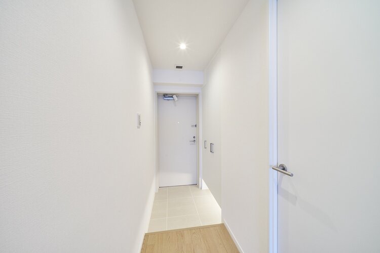 白を基調とした清潔感のある玄関です。フットライトからのびる光が足元を優しく包み込みます。