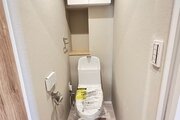 トイレ　・ウォシュレット一体型のトイレは、お掃除の手助けをしてくれる便利機能が搭載されています。上部には吊戸棚を造作しました。トイレットペーパーや掃除用品なども収納できます。