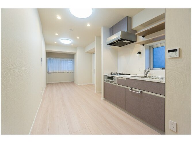 柔らかな色合いのフローリングと清潔感のあふれる白のクロスが明るい空間を創り出しているLDK。