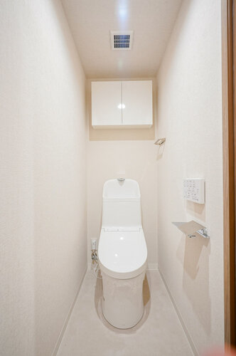 温水洗浄便座付トイレ。上部には収納スペースを設置しており、トイレットペーパーや掃除用品をしまえます